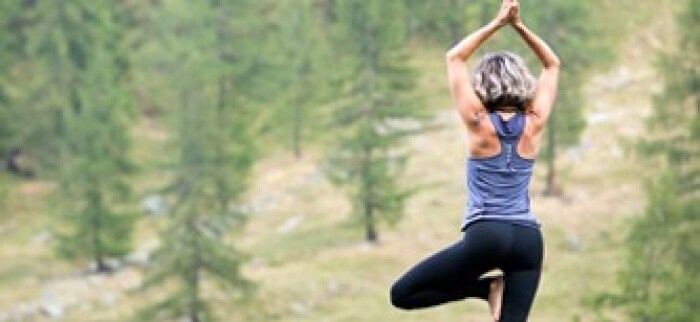 Une femme fait du yoga dans la forêt