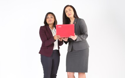 Deux femmes tiennent un ordinateur portable.