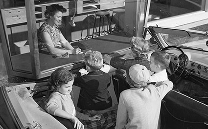 A group of women parked at a drive-through bank.
