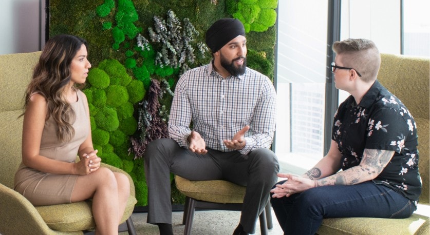 Trois employés de la Banque CIBC discutent dans un espace commun.