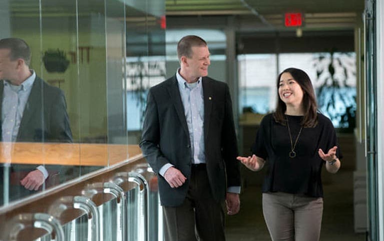 A man and woman walking through the office