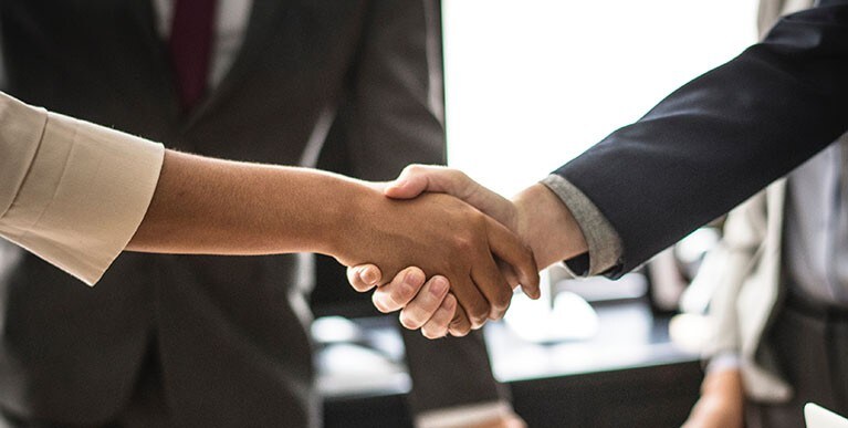 Two racially diverse professionals shaking hands