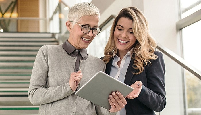 Two women review our research insights on a tablet