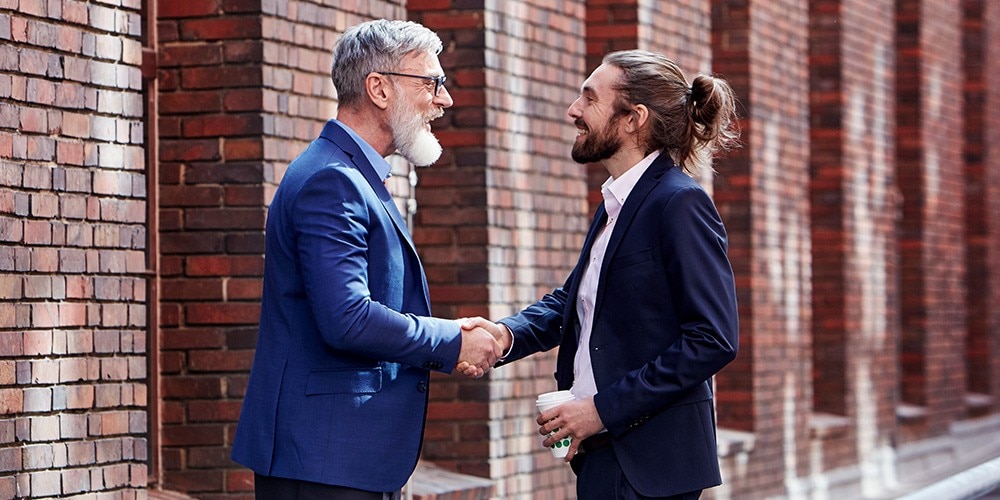 A Financial Services Representative shakes hands with a client.