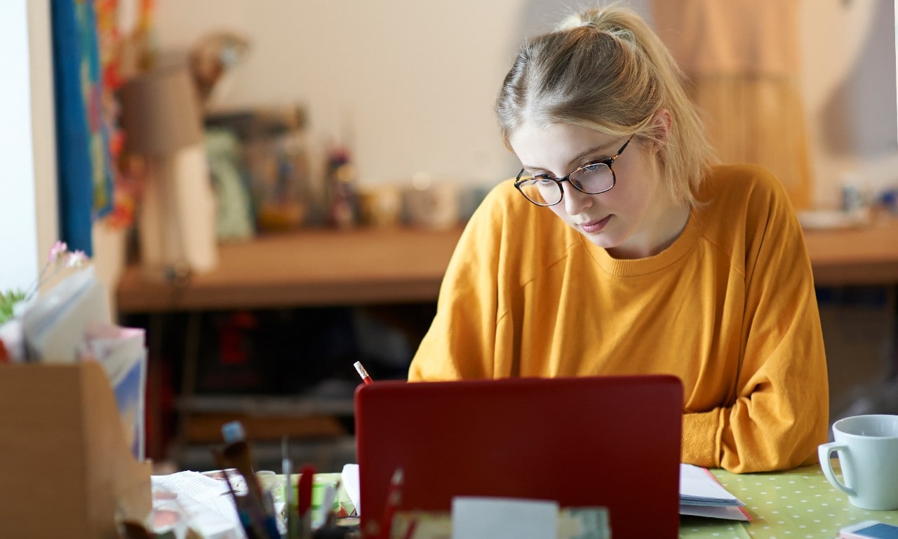 Une jeune femme assise à une table étudie