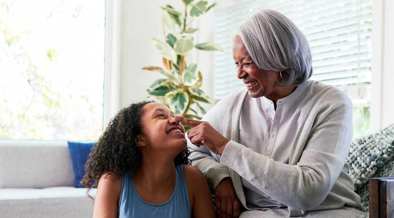 A grandmother being playful with her granddaughter