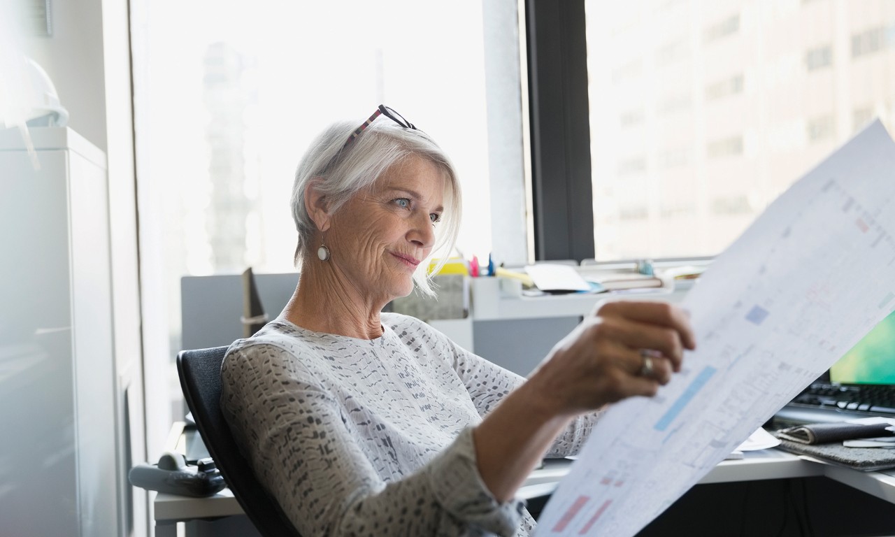A woman reviewing a floor plan in her office