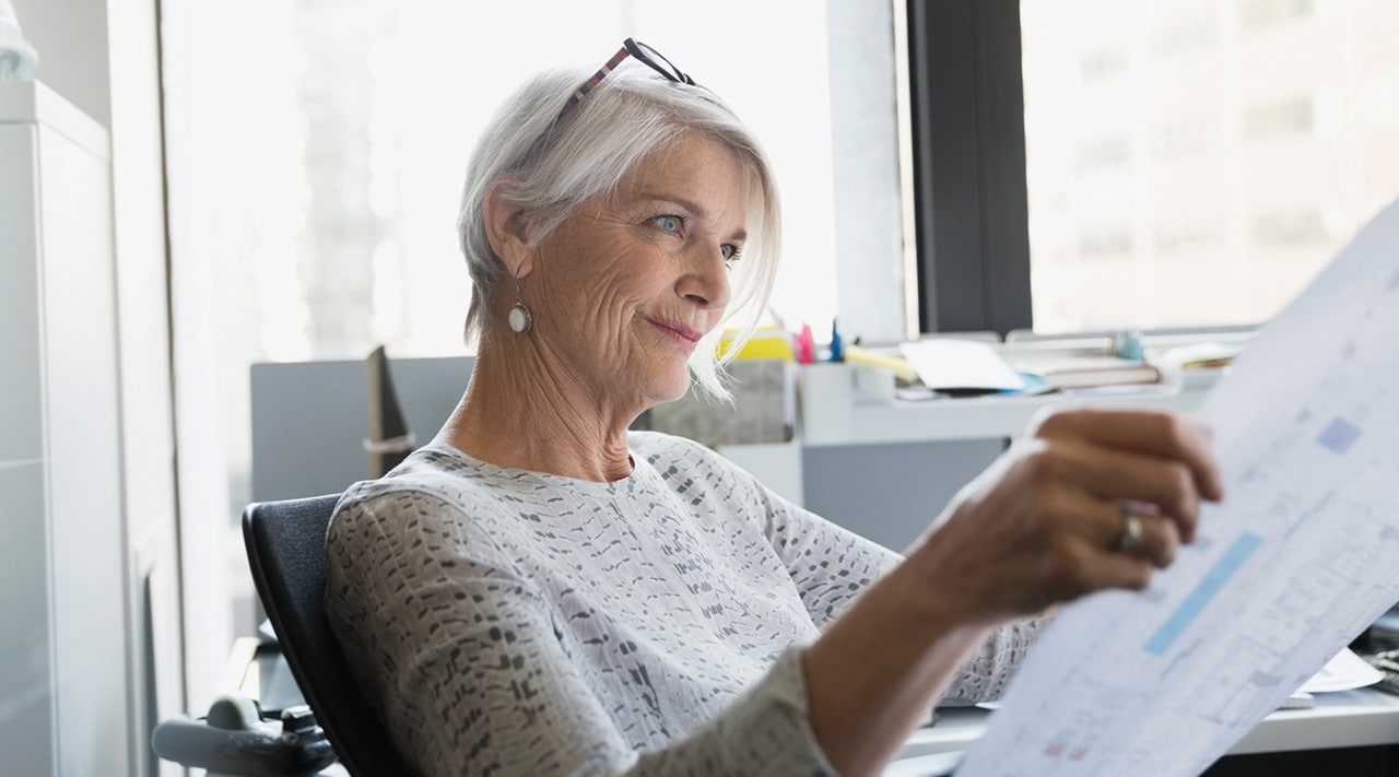 A woman reviewing a floor plan in her office