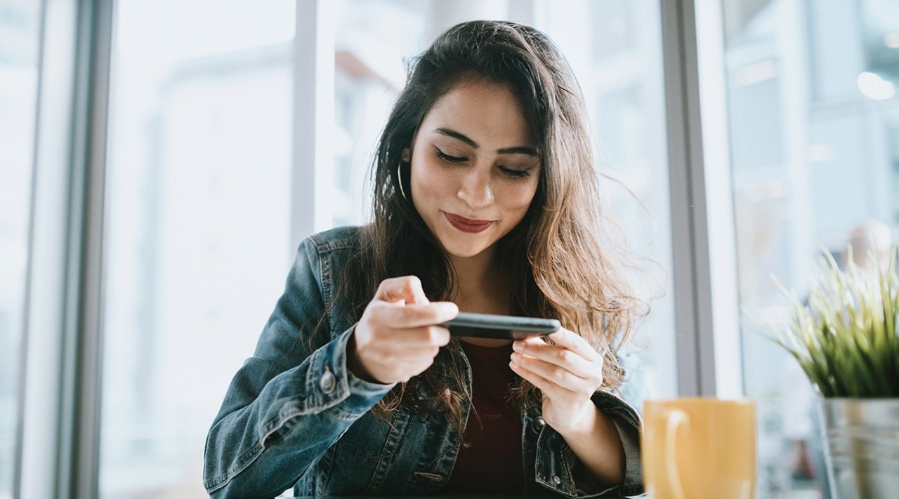 Une jeune femme utilise son téléphone dans un café