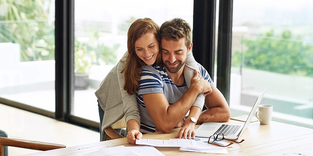 Un couple heureux regarde des documents financiers