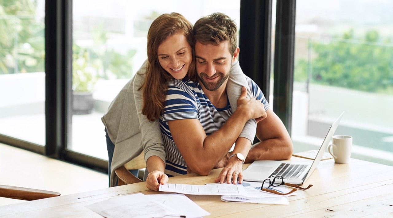 A happy couple going over financial documents