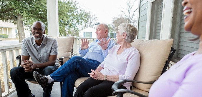 A group of retirees chatting on a porch