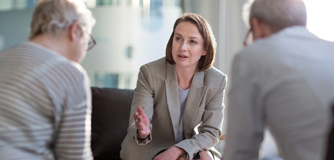 Une conseillère financière rencontre des clients.