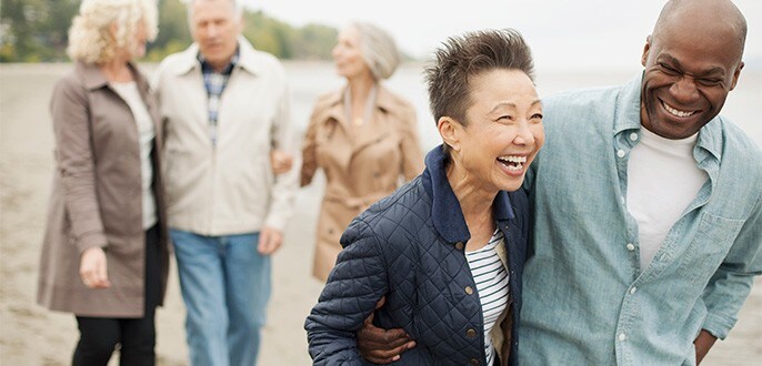 A group of retirees taking a walk at a beach