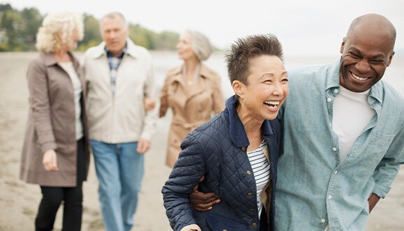 A group of retirees taking a walk at a beach