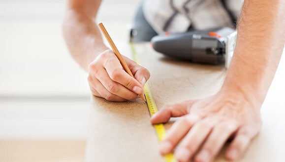 Un charpentier prend des mesures.