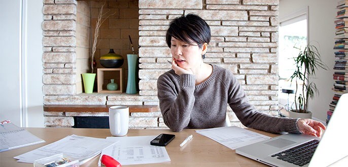 A woman on her laptop, going through documents