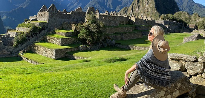 Une femme assise sur une roche à Machu Picchu