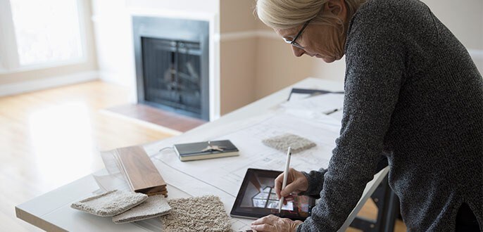 A woman choosing swatches and planning out home renovations on her tablet