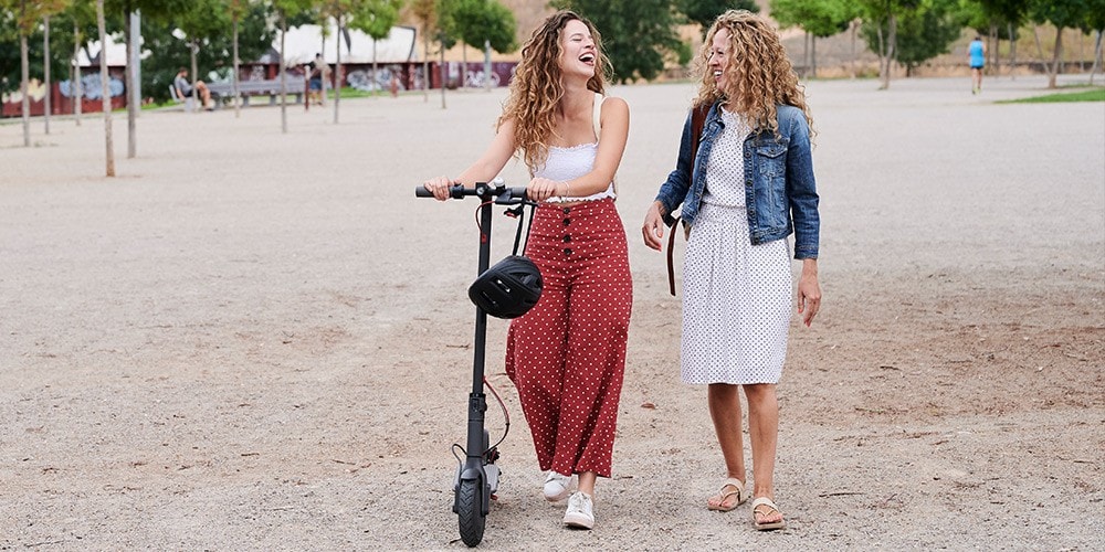 Two friends laugh as they walk together.