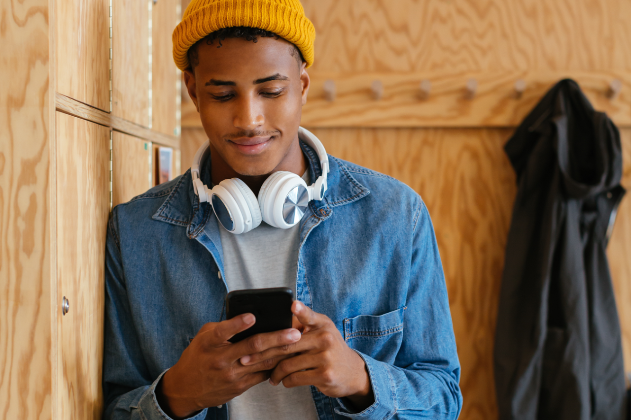 Un client souriant qui utilise l'application sur son téléphone intelligent