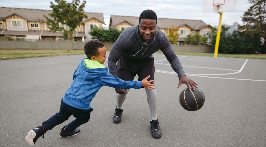 A parent and child play basketball