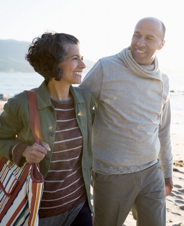 A happy couple walk outdoors on a sunny day