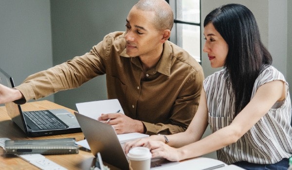 Man and woman working together on their laptops