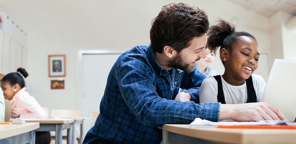 Male teacher helping students with their homework