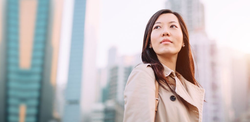 Woman standing outside with office buildings in the background