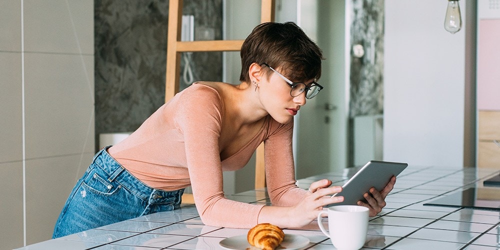 Woman reading on her tablet in the kitchen