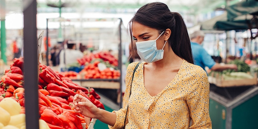 Woman carrying her groceries and a bouquet of flowers.