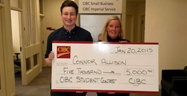 Photo de Connor Allison tenant un chèque de cinq mille dollars