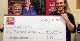 Photo de Shane Morris tenant un chèque de cinq mille dollars