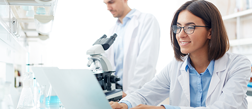 A lab technician typing on her laptop
