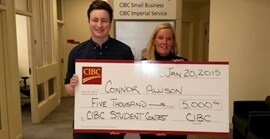 Connor Allison holding a cheque for 5,000 dollars