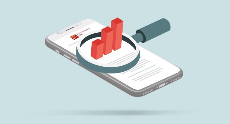 Une loupe sur un téléphone intelligent à l’écran duquel figure un graphique présentant des placements en croissance