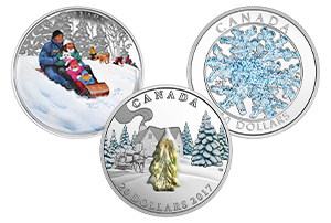 A silver coin illustrating a family speeding down a slope on a toboggan; a silver coin featuring snow-covered trees with Murano glass; and a silver coin featuring a snowflake with glitter enamel.
