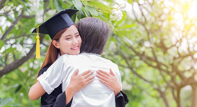 A mother hugging her daughter on graduation day.