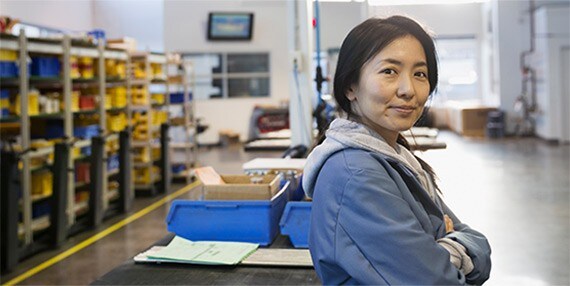 Confident worker with arms crossed in factory