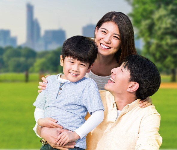 A smiling family in a park.
