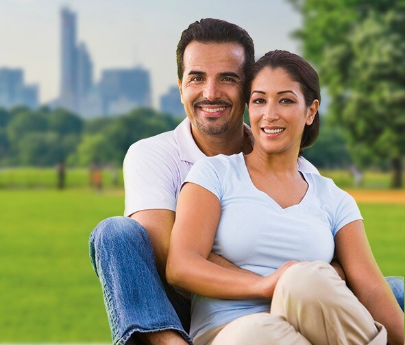 A smiling family in a park.
