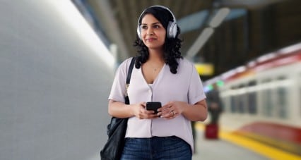 Woman with headphones on listening to music on her smartphone